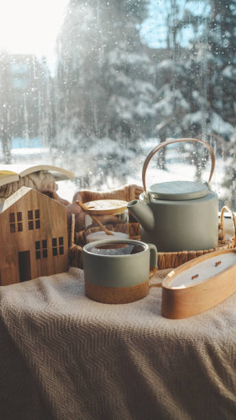 istock Cozy winter home interior, candle, tea and teapot on the windowsill 1960624901