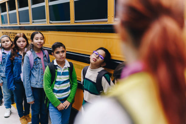 istock Child students waiting to get on the school bus 1960675604
