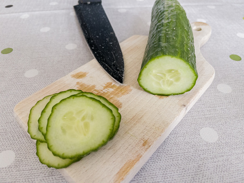 A cucumber on a kitchen board.