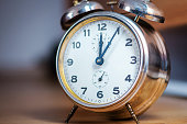 An aged metallic desk alarm clock.