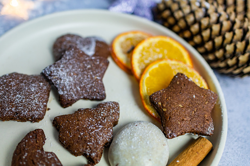 Gingerbread cookies with sliced orange decoration and spices, cinnamon sticks and cloves.