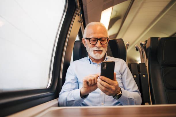 istock Senior businessman using his mobile phone while traveling with train 1960687269