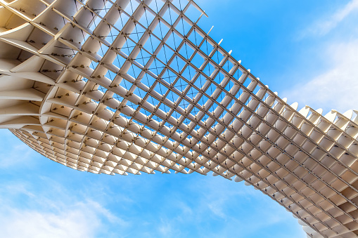Sevilla, Spain – December 20, 2023: Detail of the Metropol Parasol, known as the Mushrooms (Spanish: Las Setas), is a structure with two columns that hold the access elevators to a famous viewpoint.