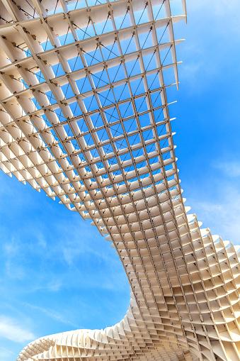 Sevilla, Spain – December 20, 2023: Detail of the Metropol Parasol, known as the Mushrooms (Spanish: Las Setas), is a structure with two columns that hold the access elevators to a famous viewpoint.