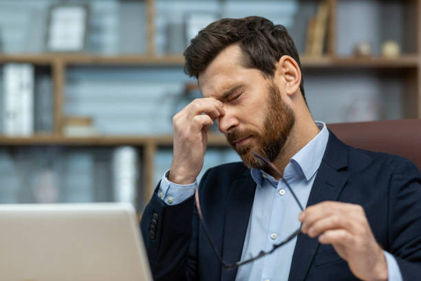 istock Stressed mature businessman rubbing eyes while working on laptop in a classic office 1960690482