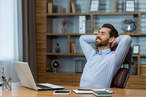 istock Successful businessman relaxing in his office with hands behind head, satisfied with work 1960690484