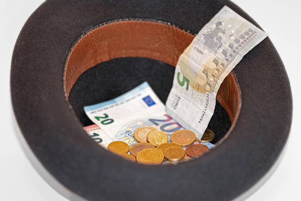 Political fund raising / contributions. A Patriotic skimmer hat sits full of bundles of $100 bills with reflection on a white background