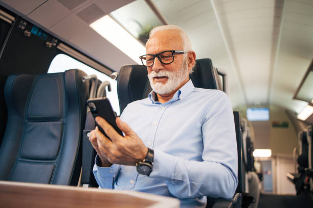 istock Senior businessman using his mobile phone while traveling with train 1960698834