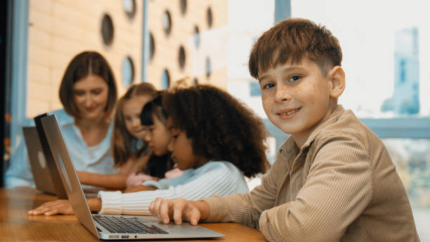 istock Boy looking at camera with multicultural friend learning prompt. Erudition. 1960730216