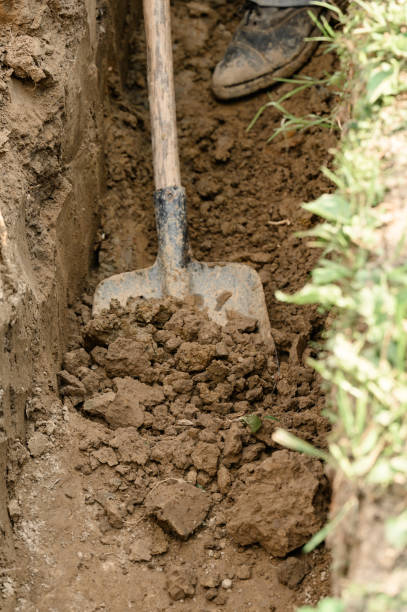 istock A man shovels a trench for drainage and sewage. 1960733874