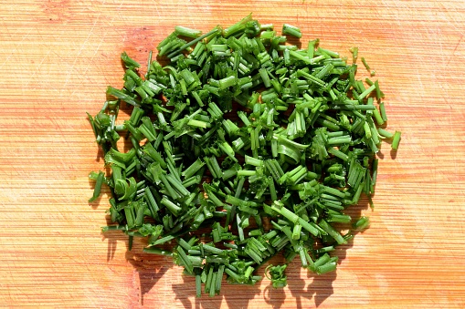 Fresh chopped chives on cutting board