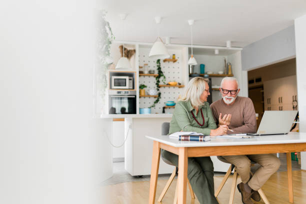 istock Senior couple using laptop while planning their home budget, 1960753289