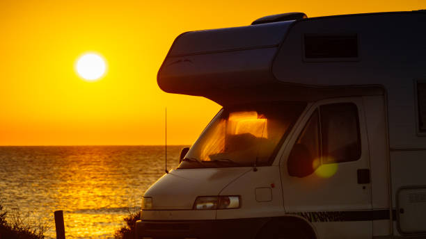 istock Camper vehicle on beach at sunrise 1960755422