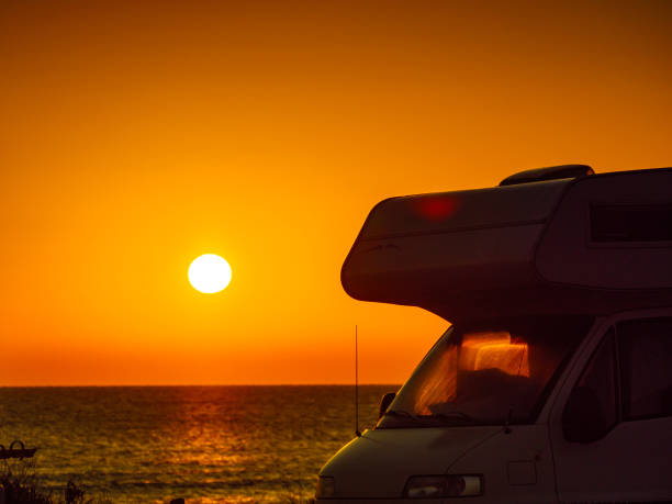 istock Camper car on beach at sunrise 1960758098