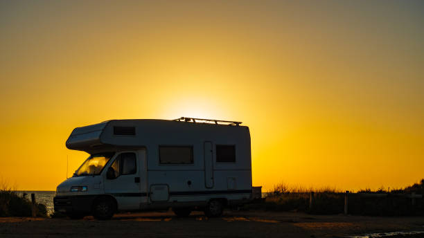 istock Camper rv on sea at sunrise 1960760155