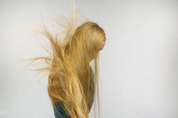Girl hiding face with long blonde hair. Shame, shyness.
