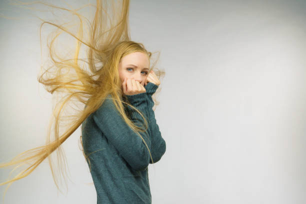 Sad melancholy young woman with blowing long blonde hair.