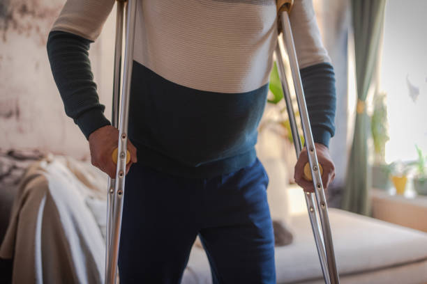 Disabled person walks with crutches