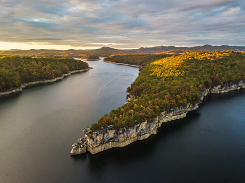 The late evening sunlight grazes the tops of the hills above the cliff lines of Summersville Lake in early Autumn.