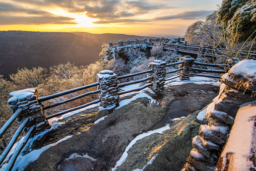 The sun sets over the snow and ice covered barricades that surround Coopers Rock in Morgantown, West Virginia.