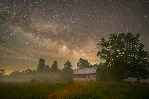 Fireflies dot the fields around a barn under the great Milky Way as a fog begins to lift from the surrounding countryside in Randolph County, West Virginia.