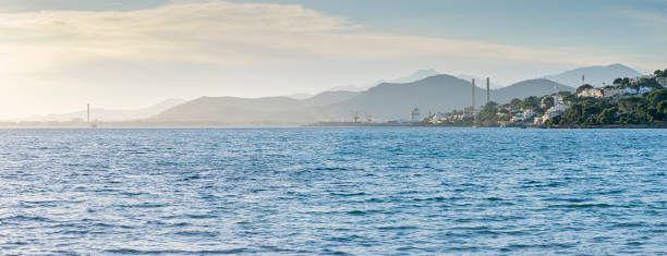 istock Industrial Harmony: Mountains and Factories by the Sea 1960843203