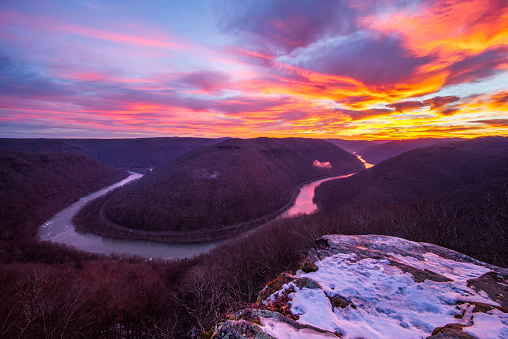 The morning sunrise sets a colorful sky against the late wintery back drop at Grandview State Park overlooking the New River in West Virginia.