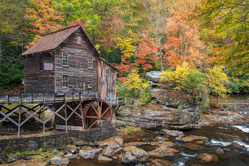 The historic grist mill at Babcock State Park in West Virginia, sits along Glade Creek surrounded by colorful autumn foliage.