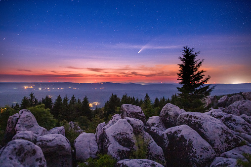 The comet NEOWISE can be seen in the darkening summer twilight above Canaan Valley, West Virginia from a high vista on the western edge of the Dolly Sods Wilderness Area.