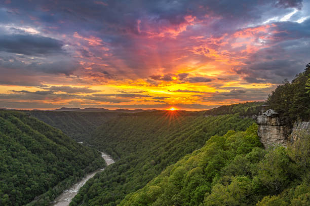 The sun's rays leave behind an explosion of colors as the storm clouds break over the New River Gorge from Beauty Mountain.