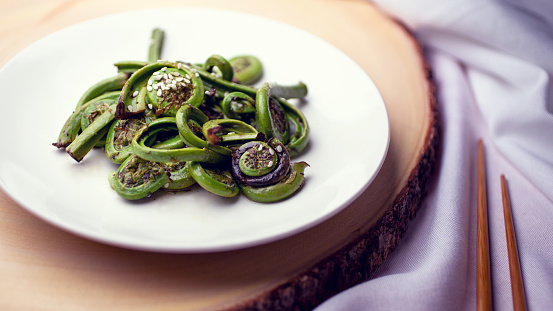 A view of a plate of cooked fiddleheads.