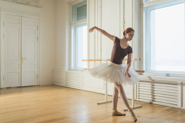 istock Young ballerina in tutu skirt dancing practicing ballet positions in dance class. Young classical dancer woman in dance studio. Ballet class training. Ballet school concept. 1960860939