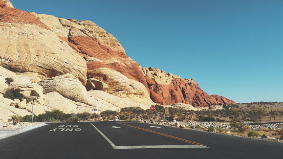 A view of a geological rocky mountain formation located inside Red Rock Canyon National Conservation Area, with a paved road.