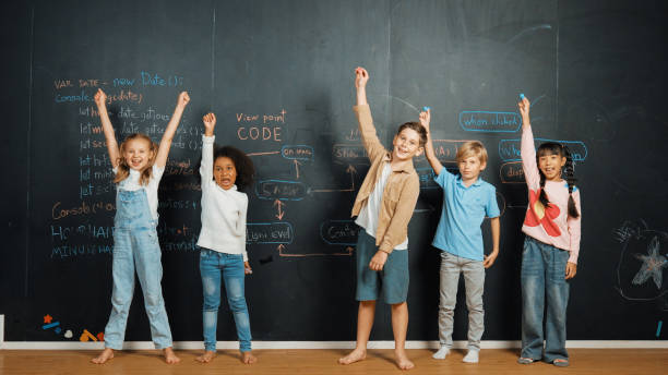 istock Happy diverse student raising hands up while standing at blackboard. Erudition. 1960873842