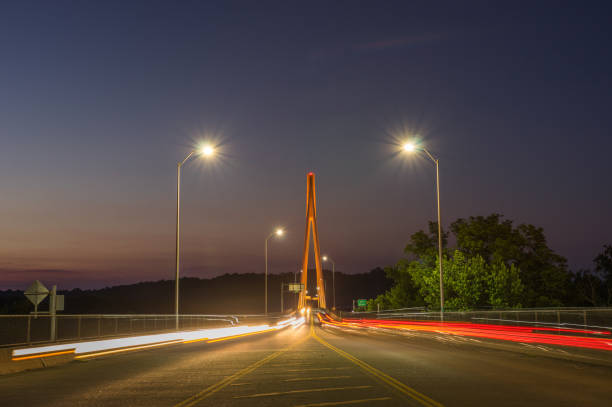 Travelers drive north and south on the East Huntington suspension bridge from Huntington into Ohio at twilight.
