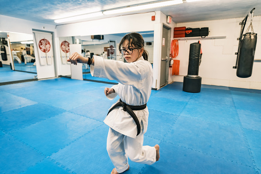Young Karate fighters, school age children practising karate. They are all dressed in karategi-karate uniform. Interior of karate school in Mississauga, Ontario in Canada.