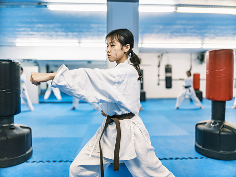 Young Karate fighters, school age children practising karate. They are all dressed in karategi-karate uniform. Interior of karate school in Mississauga, Ontario in Canada.