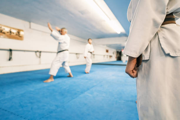 Sensei (karate master) teaching Young Karate fighters in karate school. They are all dressed in karategi-karate uniform. Interior of karate school in Mississauga, Ontario in Canada.