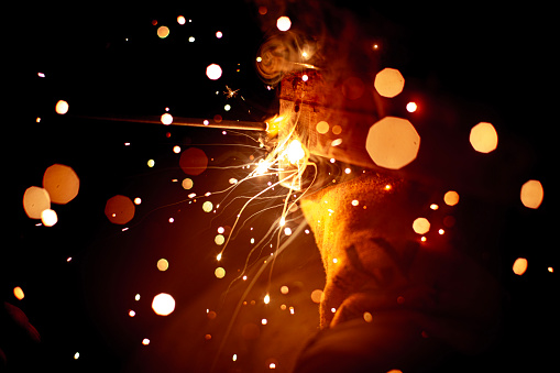 smoke and sparks close-up from electric arc welding in the dark