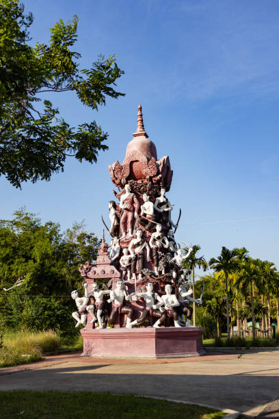 A statue of Buddha surrounded by birds, with the birds perched on his shoulders and feeding.
