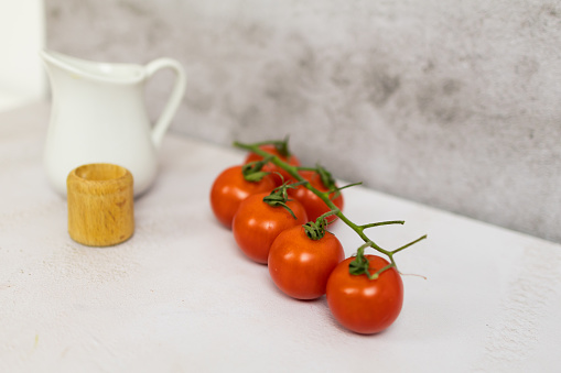 Cherry tomatoes, salt shaker and cooking oil jug.