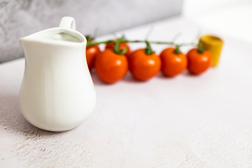Cherry tomatoes, salt shaker and cooking oil jug.