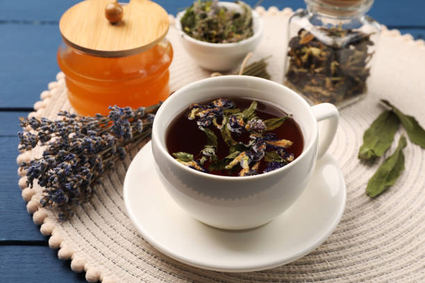 istock Aromatic tea with different dry herbs and honey on blue wooden table, closeup 1960964219