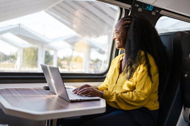 istock Young woman using laptop in a train 1960964759