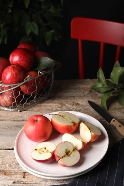 istock Fresh red apples, leaves and knife on wooden table 1960973235