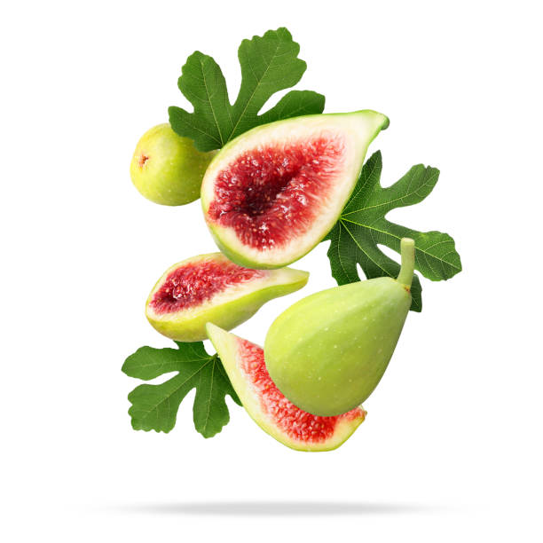 istock Ripe figs and green leaves falling on white background 1960975917