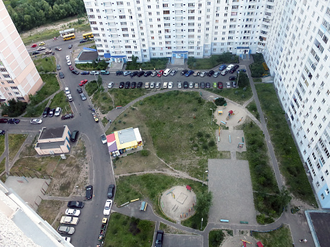 View down from the skyscraper to the car park below, the playground and other city infrastructure. Urban landscape