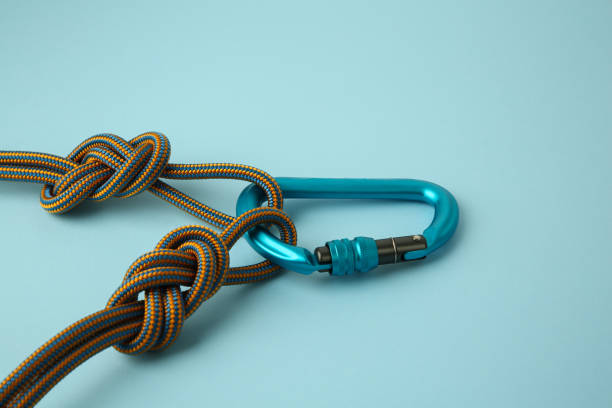 istock One metal carabiner with ropes on light blue background, closeup 1961061265