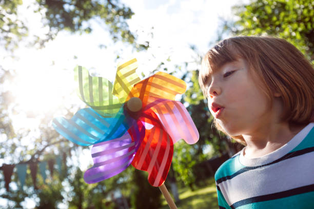 Portrait of a cute little boy with rainbow pinwheel toy.