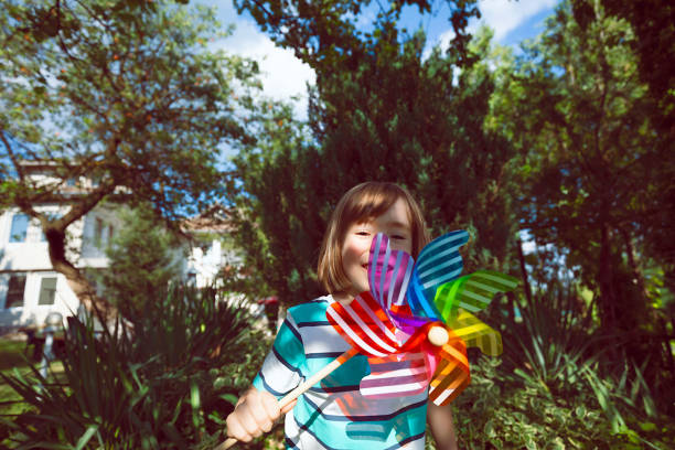 Portrait of a cute little boy with rainbow pinwheel toy.
